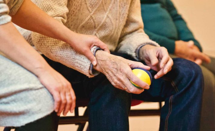 a woman holding an elderly's hand