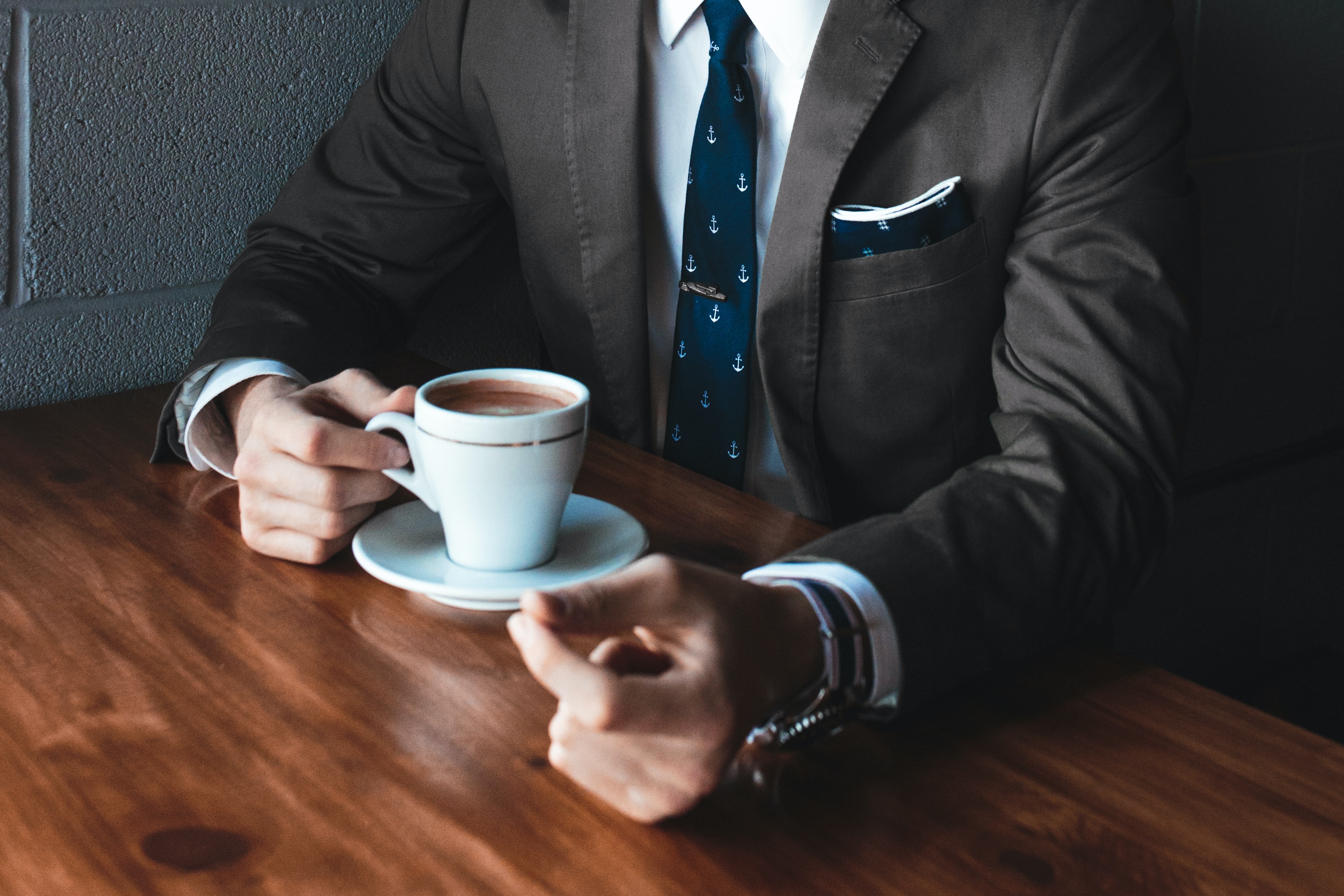 a man in a suit drinking coffee