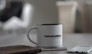 a white mug with the word 'conversations' printed