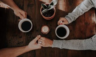 a couple drinking coffee and holding hands