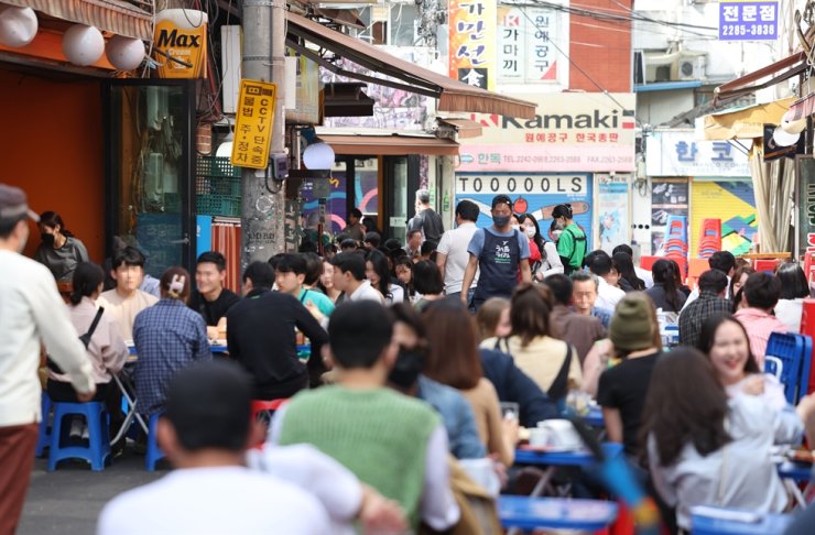 People drink and eat outdoors in downtown Seoul