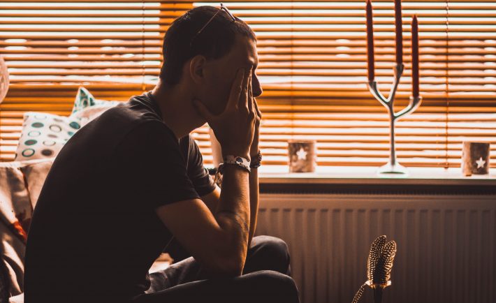 a stressed man sitting on a couch