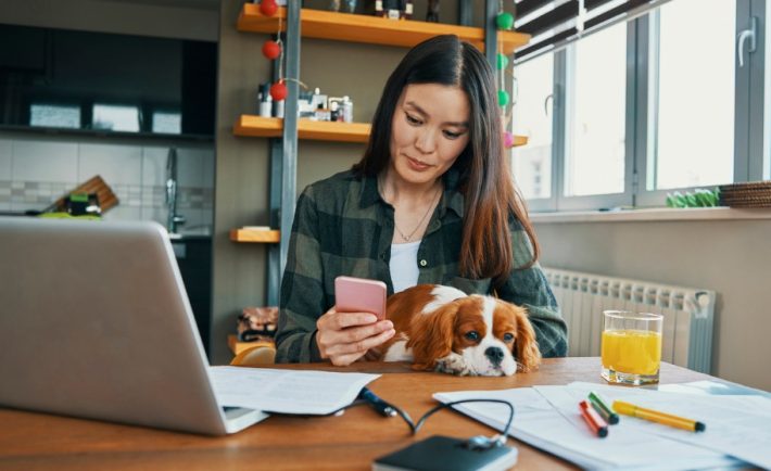 woman checking her phone while working from home