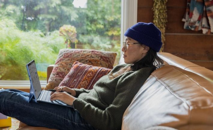 a person sitting at a table using a laptop