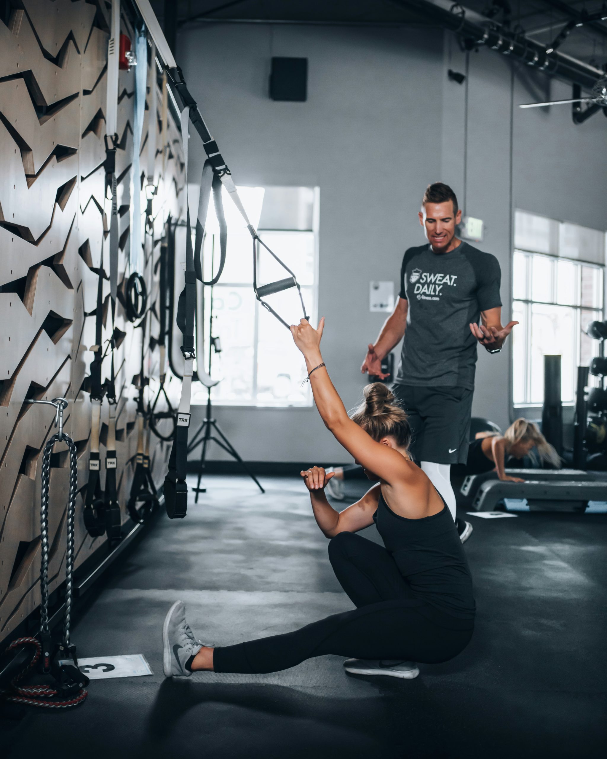 a male personal trainer guiding a female