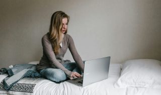 woman working on her laptop in bed