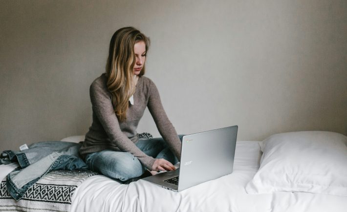 woman working on her laptop in bed