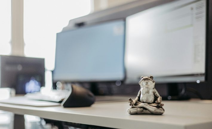 a frog statue on a work desk